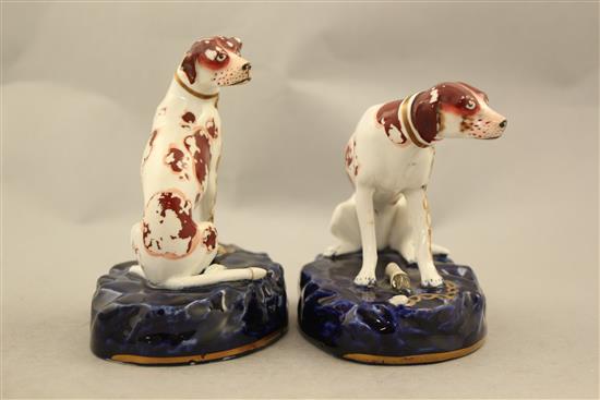 A pair of English porcelain figures of seated hounds, c.1830, 11.5cm and 12.5cm, flaking to enamels